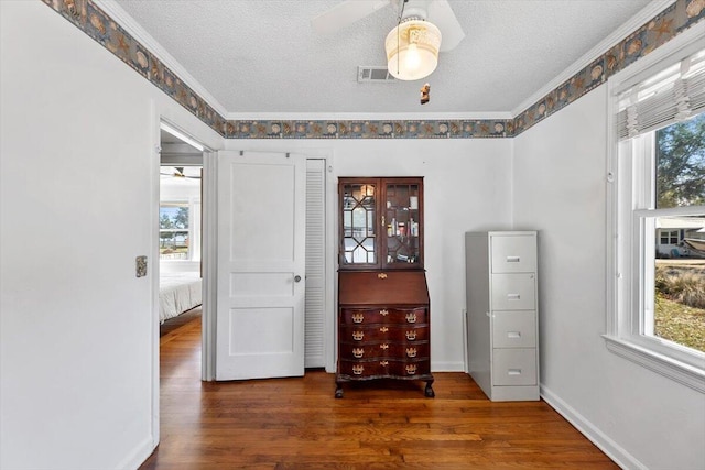 interior space with multiple windows, visible vents, a textured ceiling, and wood finished floors