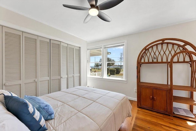 bedroom featuring ceiling fan, a closet, and wood finished floors