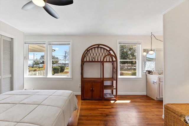 bedroom featuring a ceiling fan, a closet, baseboards, and wood finished floors