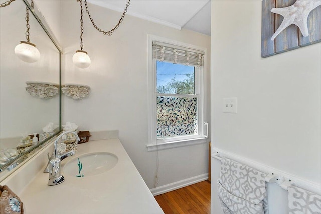 bathroom with wood finished floors, vanity, and baseboards