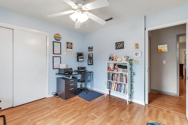 office space featuring a ceiling fan, baseboards, visible vents, and light wood finished floors