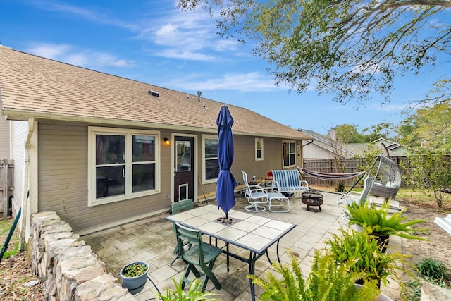 rear view of house featuring a patio, a fire pit, and fence