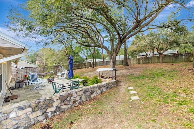 view of yard with an outdoor fire pit, a patio area, and a fenced backyard