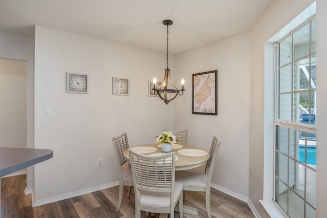 dining area featuring dark wood-type flooring and a chandelier