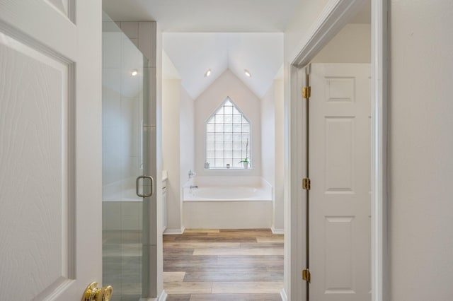 bathroom with lofted ceiling, wood-type flooring, and separate shower and tub