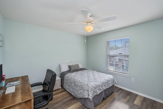 bedroom with dark wood-type flooring, ceiling fan, and a textured ceiling