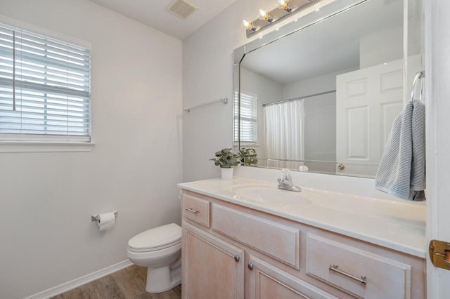 bathroom featuring walk in shower, vanity, toilet, and hardwood / wood-style floors