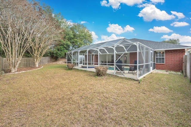 rear view of property with a yard, a fenced in pool, a patio area, and glass enclosure