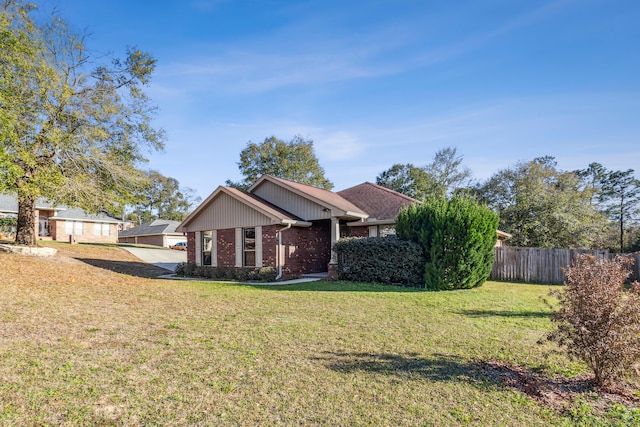 view of front facade featuring fence, a front lawn, and brick siding