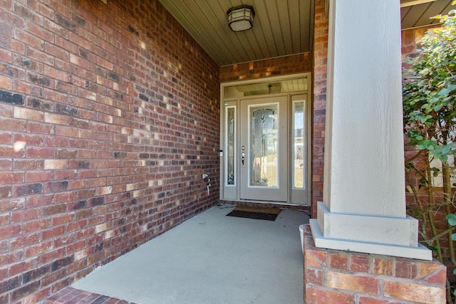 view of exterior entry featuring brick siding