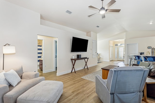 living area with lofted ceiling, ceiling fan, visible vents, baseboards, and light wood-type flooring