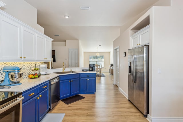 kitchen featuring a peninsula, a sink, visible vents, white cabinetry, and appliances with stainless steel finishes