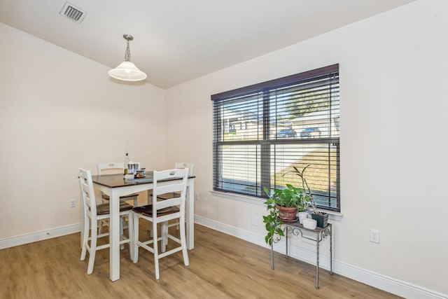 dining room featuring baseboards, visible vents, and wood finished floors