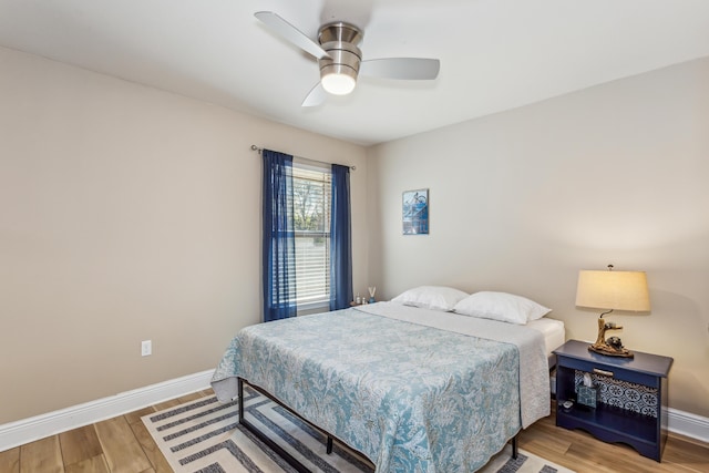 bedroom featuring a ceiling fan, baseboards, and wood finished floors