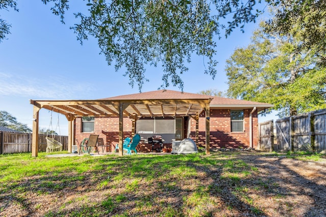 back of property featuring a lawn, a fenced backyard, a patio area, a pergola, and brick siding