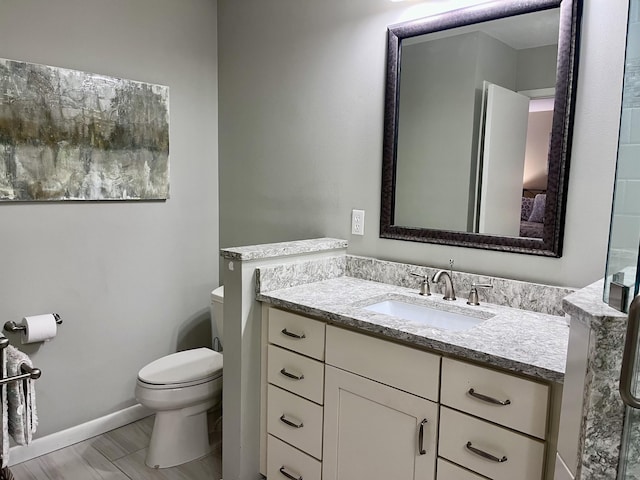 bathroom with vanity, hardwood / wood-style flooring, and toilet