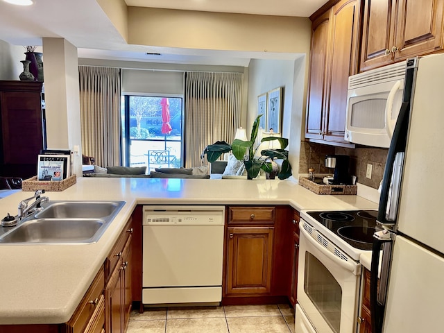 kitchen featuring sink, white appliances, light tile patterned floors, tasteful backsplash, and kitchen peninsula