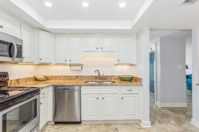 kitchen with sink, stainless steel appliances, white cabinetry, and light stone countertops
