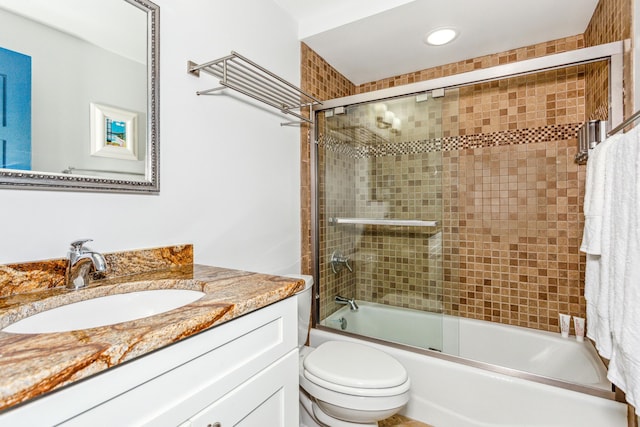 full bathroom featuring enclosed tub / shower combo, vanity, and toilet