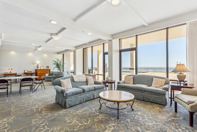 living room featuring a water view, beamed ceiling, and ceiling fan