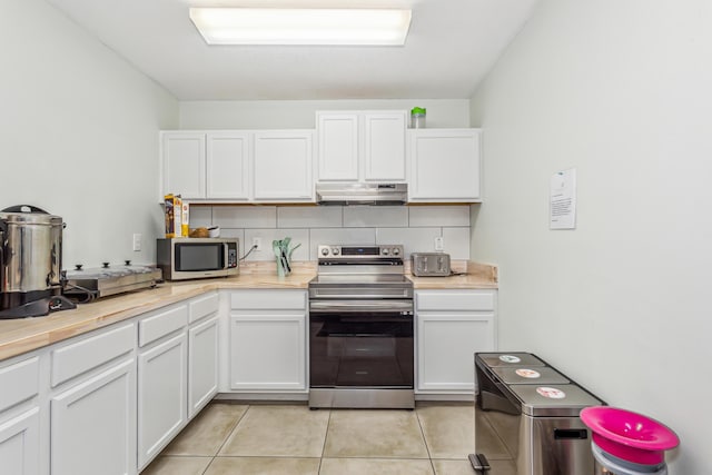 kitchen featuring light tile patterned flooring, stainless steel appliances, and white cabinets