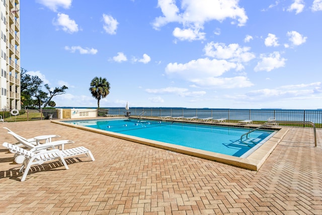 view of pool with a patio area and a water view