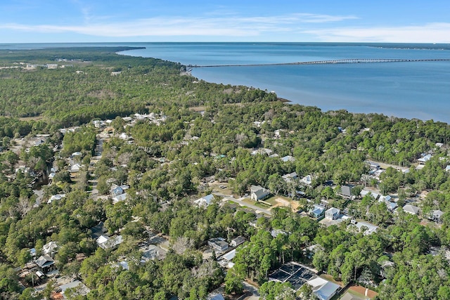 birds eye view of property featuring a forest view and a water view