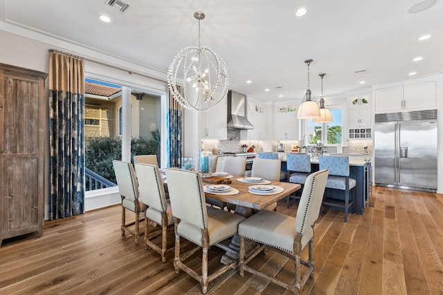 dining area featuring crown molding, a chandelier, and hardwood / wood-style floors