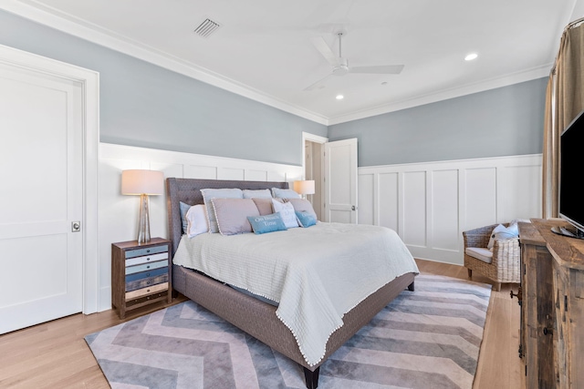 bedroom featuring light hardwood / wood-style flooring, ornamental molding, and ceiling fan