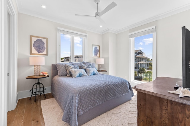 bedroom featuring multiple windows, crown molding, and light hardwood / wood-style floors