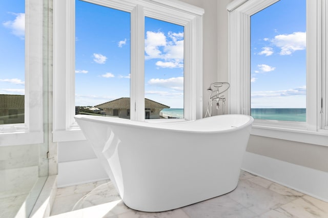 bathroom featuring a water view and a tub