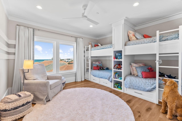 bedroom featuring crown molding, light hardwood / wood-style flooring, and ceiling fan