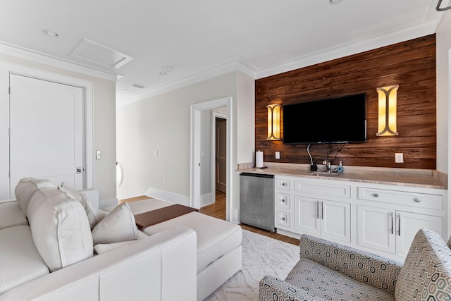 living room featuring crown molding, wooden walls, and light hardwood / wood-style floors