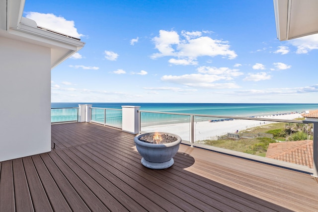 wooden deck featuring a view of the beach and a water view