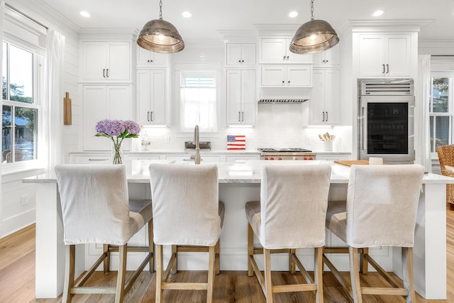 36 E Ruskin St, Santa Rosa Beach, FL 32459 - kitchen with a kitchen bar, oven, white cabinets, and a center island with sink