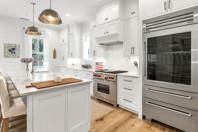 36 E Ruskin St, Santa Rosa Beach, FL 32459 - kitchen with a breakfast bar, premium stove, decorative light fixtures, a kitchen island with sink, and white cabinets