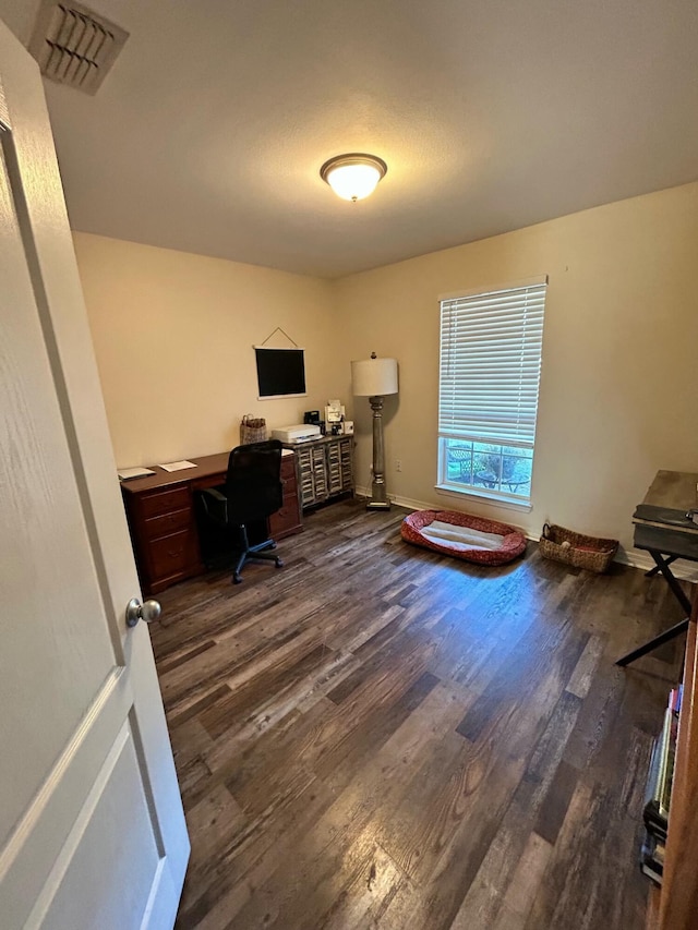 office space with baseboards, visible vents, and dark wood-style flooring