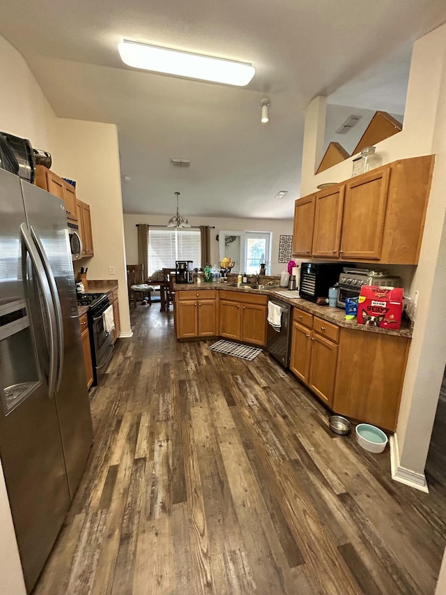 kitchen featuring lofted ceiling, stainless steel appliances, a peninsula, brown cabinets, and dark wood-style floors