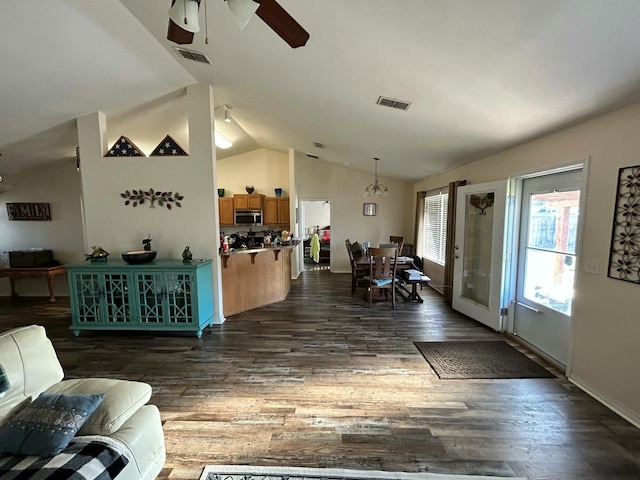 interior space with lofted ceiling, dark wood-style flooring, visible vents, and ceiling fan