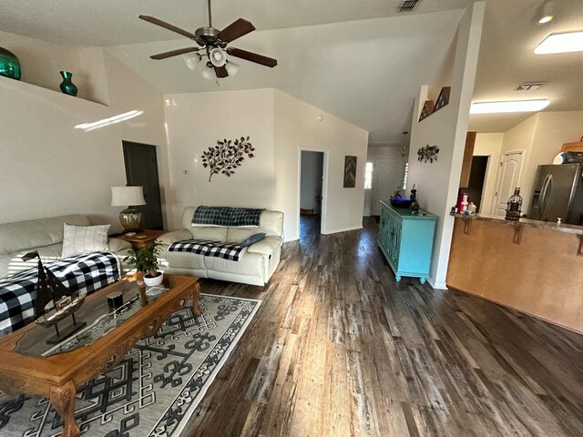 living area with lofted ceiling, ceiling fan, visible vents, and wood finished floors