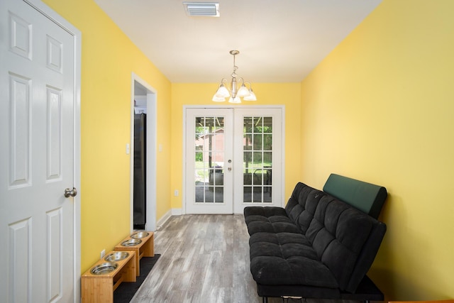 doorway featuring hardwood / wood-style flooring, a notable chandelier, and french doors