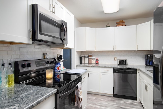 kitchen with tasteful backsplash, light stone countertops, appliances with stainless steel finishes, and white cabinets