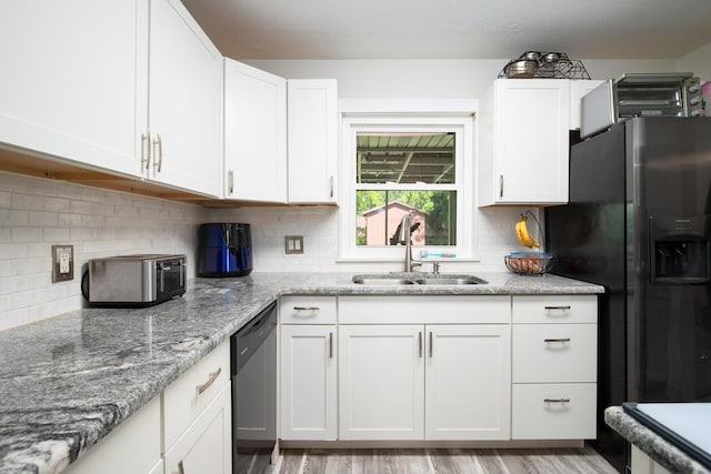 kitchen featuring sink, appliances with stainless steel finishes, light stone counters, white cabinets, and light wood-type flooring