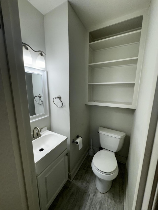 bathroom featuring vanity, hardwood / wood-style floors, and toilet