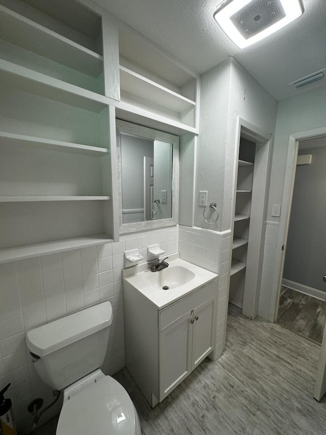 bathroom with vanity, hardwood / wood-style flooring, toilet, and a textured ceiling