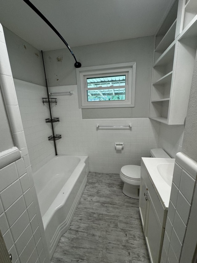 full bathroom featuring toilet, tile walls, vanity, tiled shower / bath combo, and hardwood / wood-style floors