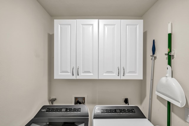 washroom with washer and dryer and cabinet space