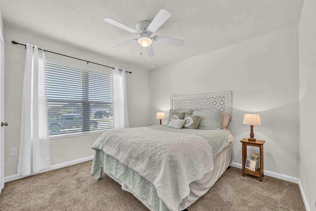 carpeted bedroom with ceiling fan and baseboards