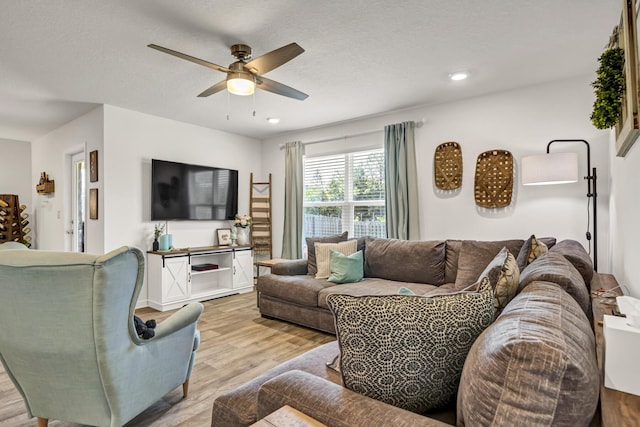 living area featuring ceiling fan, light wood finished floors, a textured ceiling, and recessed lighting