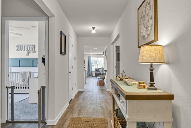 corridor featuring baseboards and wood finished floors